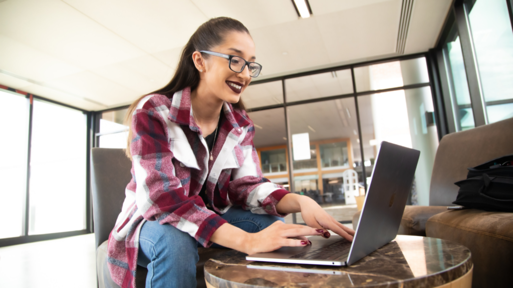 Female student sitting in lounge looking at laptop